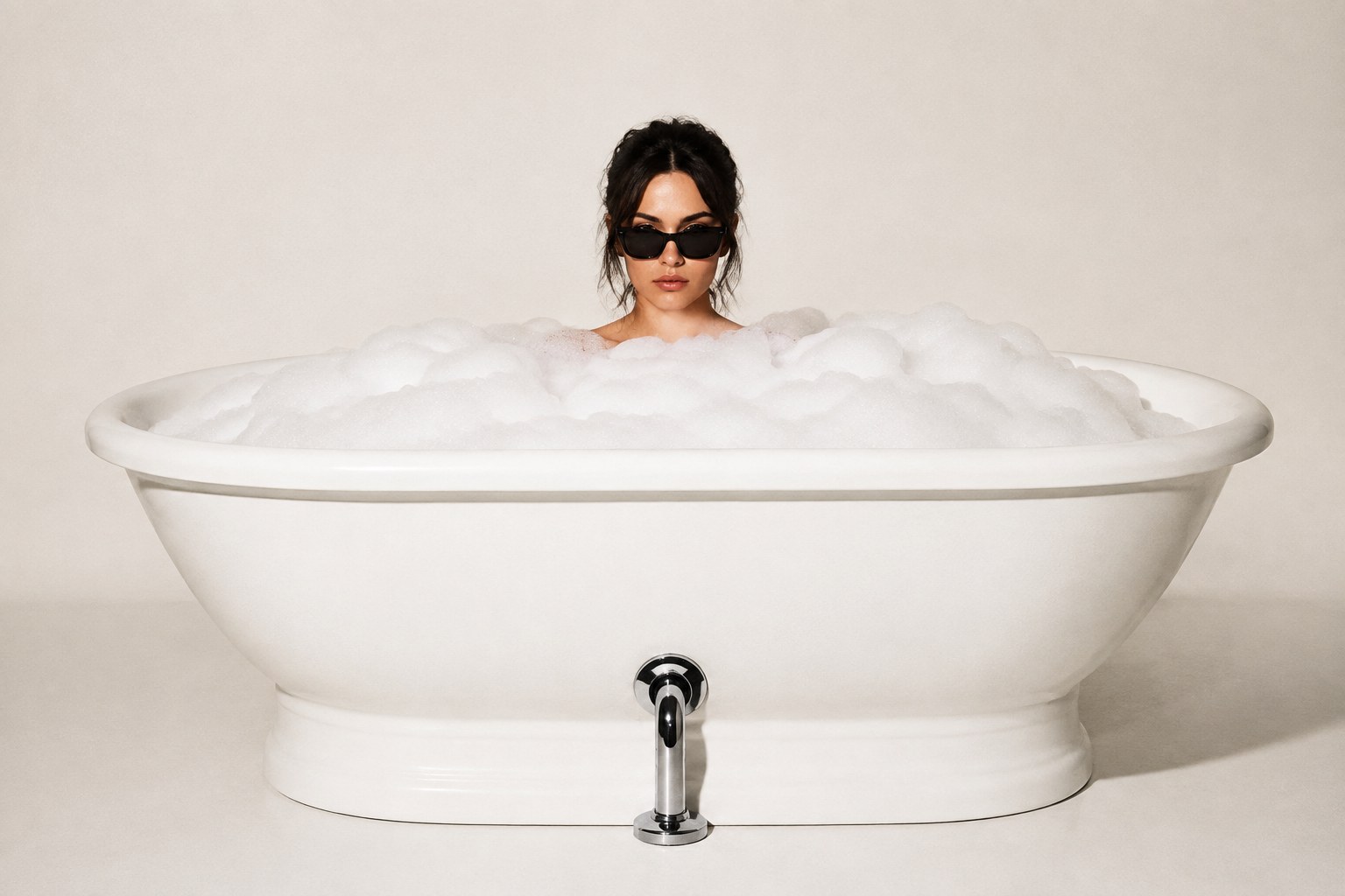 An unconcerned woman in sunglasses relaxing in a freestanding bubble bath